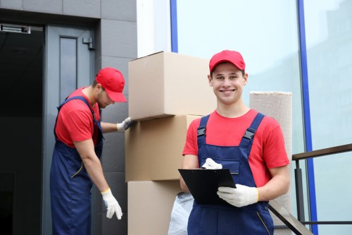 Movers carrying furniture through a Hackney flat with narrow stair access